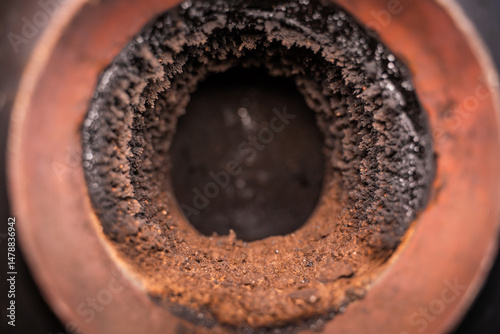 Pipe in the wall for connecting a fireplace. Chimney pipe in the wall, close-up. Soot on the inside of the pipe, maintenance and cleaning