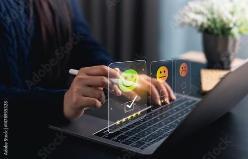 Close-up hand woman interacts with a laptop to express feedback using emotion icons and star ratings, reflecting the importance of customer satisfaction digital workplace.