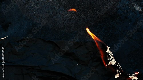 Burning and glowing edge of paper with fire flame and smoke on black background