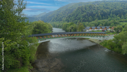 The pedestrian and bicycle bridge known as the “Broken Bridge” spanning the Dunajec River in the picturesque Pieniny Mountains, close to the town of Kroscienko, Poland.