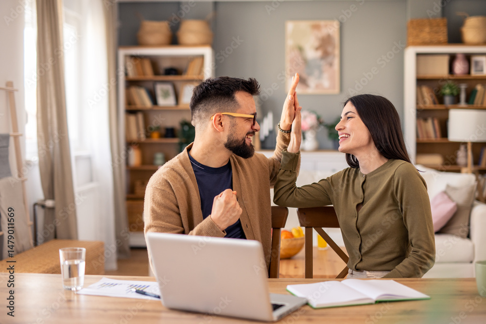 Enthusiastic Business Partners Celebrate Success With High Five In Naturally Lit Modern Home Workspace Enthusiastic Business Partners Celebrate Success With High Five In Naturally Lit Modern Home Workspace
