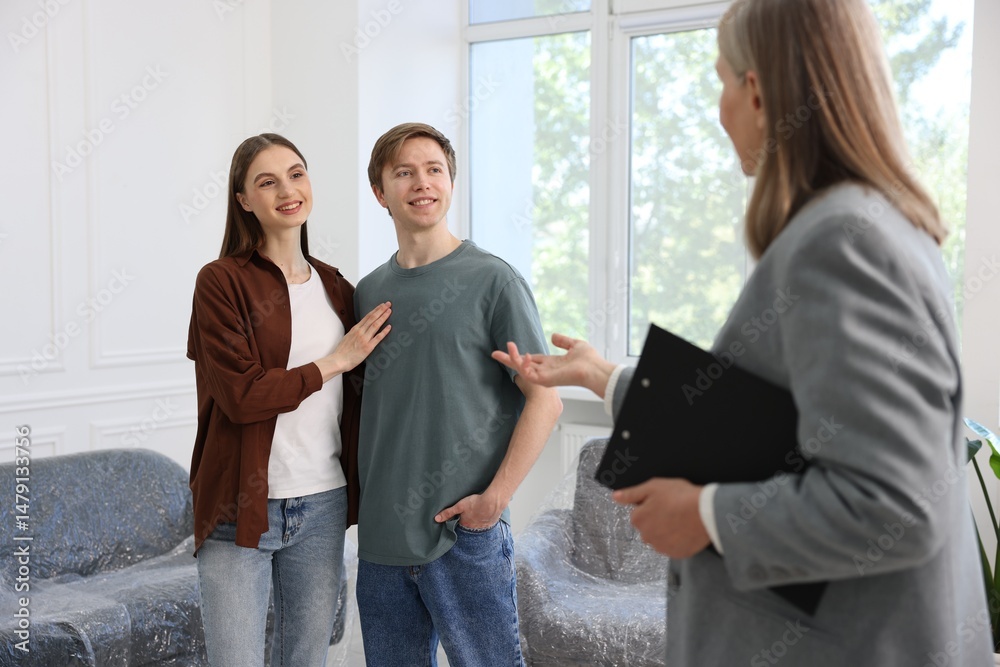 Fototapeta premium Real estate agent and young couple at home, selective focus