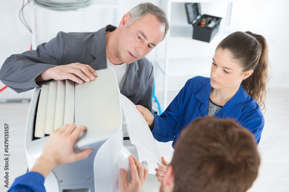 Obraz premium apprentice fixes an industrial compressor unit