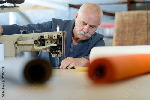 фотографія a senior upholsterer sewing cover
