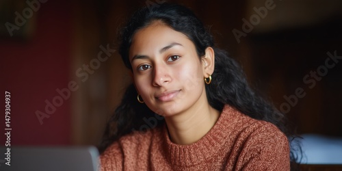 Young south asian student studying indoors with calm expression