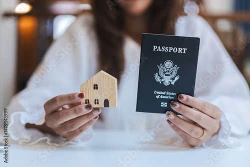 Canvastavla Person holding wooden house model and passport representing international proper