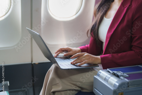 Quadro em tela Businesswoman working on laptop during flight, productivity in the air