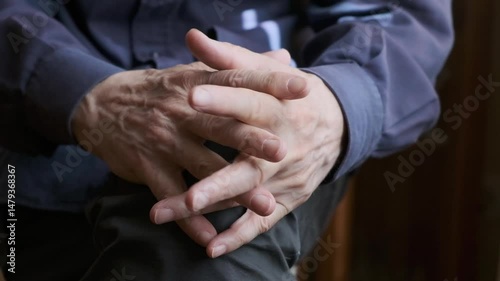 Close-Up of Folded Hands Resting on a Knee in a Relaxed Pose