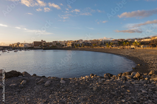 Golden sunset view of Playa de San Juan bay with protected sand beach and small harbor. Playa de San Juan is a small fishing village on the south west of Tenerife island.