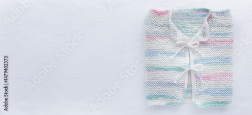 Gestricktes weisses Babyjäckchen auf weissem Hintergrund