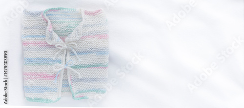 Gestricktes weisses Babyjäckchen auf weissem Hintergrund