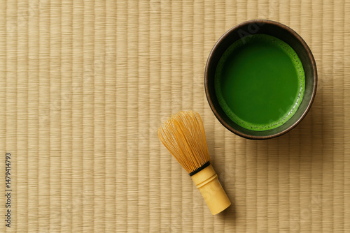 Traditional Japanese matcha tea in bowl with bamboo whisk on tatami mat, evoking calm and cultural ritual