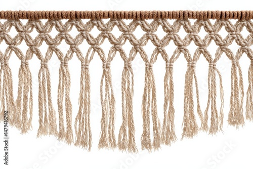 Close-up of a beige macrame textile with intricate knotting and tassels. The piece features a repeating pattern and a textured fringe.