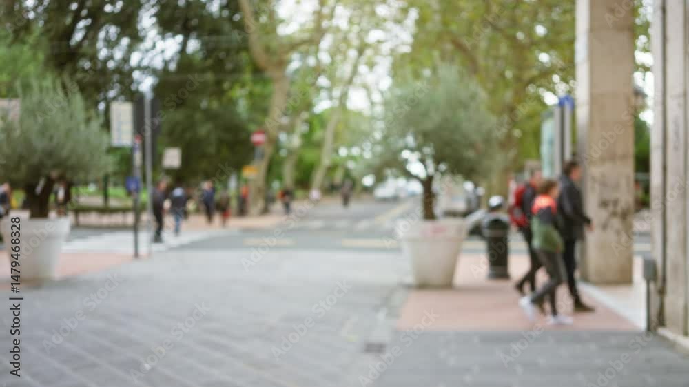 Street scene in la spezia with blurred people walking along a tree-lined area, capturing urban life in a vibrant italian town.
