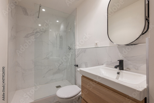 Fotografie Bathroom with white sink wooden vanity black faucet glass shower enclosure and m