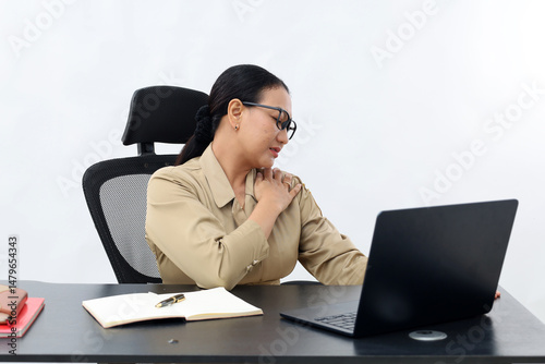 Unhappy female working in the office sitting on office desk while using laptop computer, front view, isolated on white.