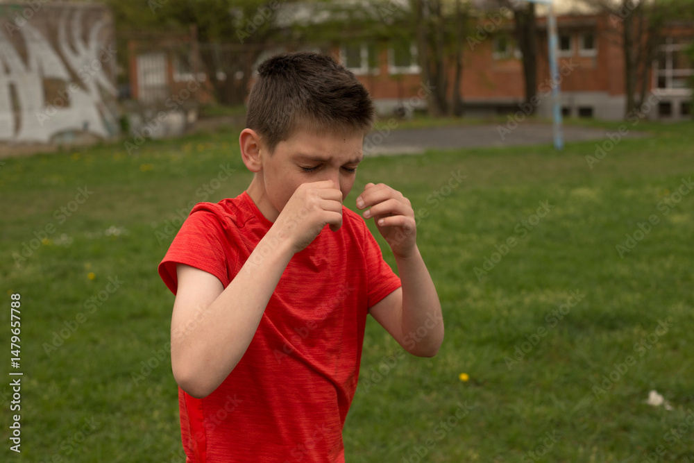 Fototapeta premium Child crying. Boy is crying, expressing raw emotion through tears and facial expression. The scene reflects vulnerability, frustration, or sadness near a school building.