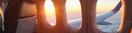 Stylish airplane wing viewed through a clean cabin window at sunrise, symbolizing refined travel elegance. LinkedIn banner format image.
