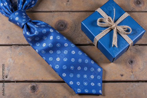 blue tie and a blue box on a wooden table