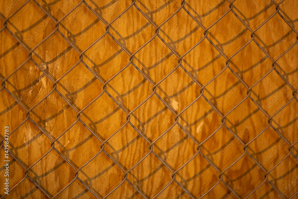 Fototapeta premium Rustic chain link fence texture on weathered wood. Perfect for backgrounds or design elements.
