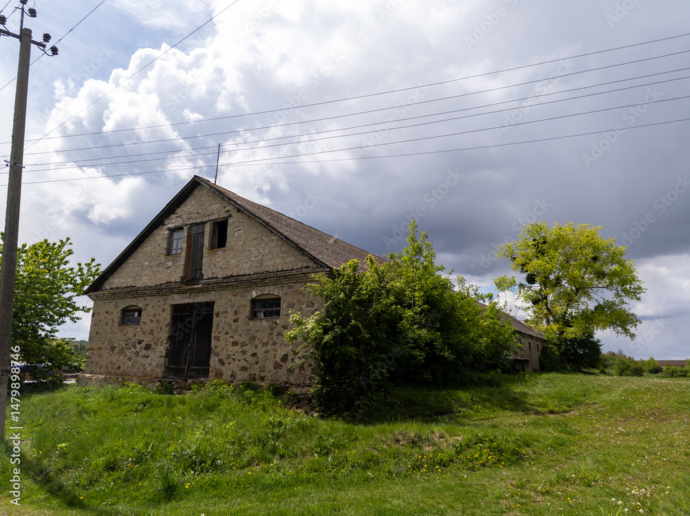 Fototapeta premium An old stone building sitting in the middle of a grassy field