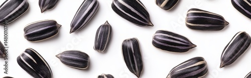 On a white background, an individual sunflower seed comes to rest, with the full range of depth in sharp focus