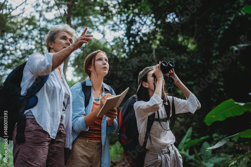 Wallpaper Mural Group of diverse women exploring nature, smiling and studying wildlife in the forest, holding notebook and binoculars, environmental education, outdoor adventure, ecological awareness Torontodigital.ca