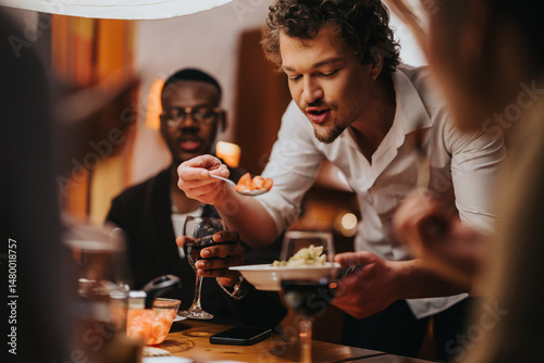 A warm and inviting scene of friends sharing food and drinks around a dining table. photo