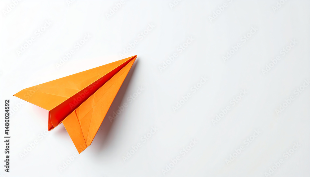 A vibrant orange paper airplane rests on a clean, white background, symbolizing creativity, childhood, and the joy of flight A vibrant orange paper airplane rests on a clean, white background, symbolizing creativity, childhood, and the joy of flight
