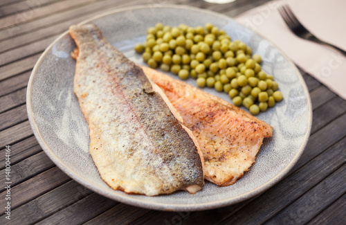 Obraz na płótnie Top view of baked trout fillet served on plate with peas closeup w salonie