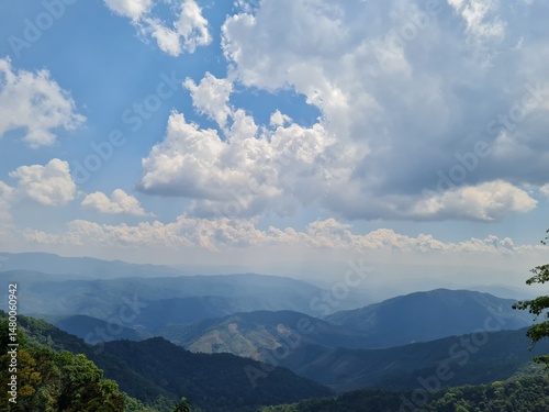 Majestic mountain vista under a vibrant sky filled with fluffy clouds