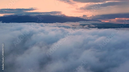 Aerial drone view of flying in sunrise clouds. The clouds are moving on camera. Concept of infinity, flight, ralax, freedom, peace