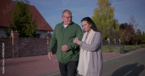 Couple strolling side by side on a suburban street, enjoying a calm moment together in a quiet and peaceful neighborhood setting