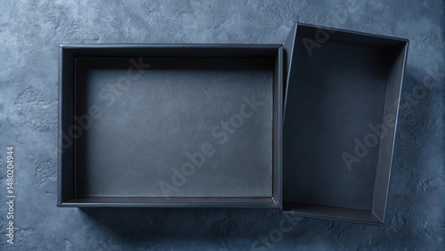 A top view of an open, empty black box with a textured dark blue background.
