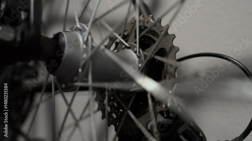 Close-up of a bicycle wheel spinning at high speed, focusing on the moving spokes. Perfect for concepts of energy, mechanics, or motion