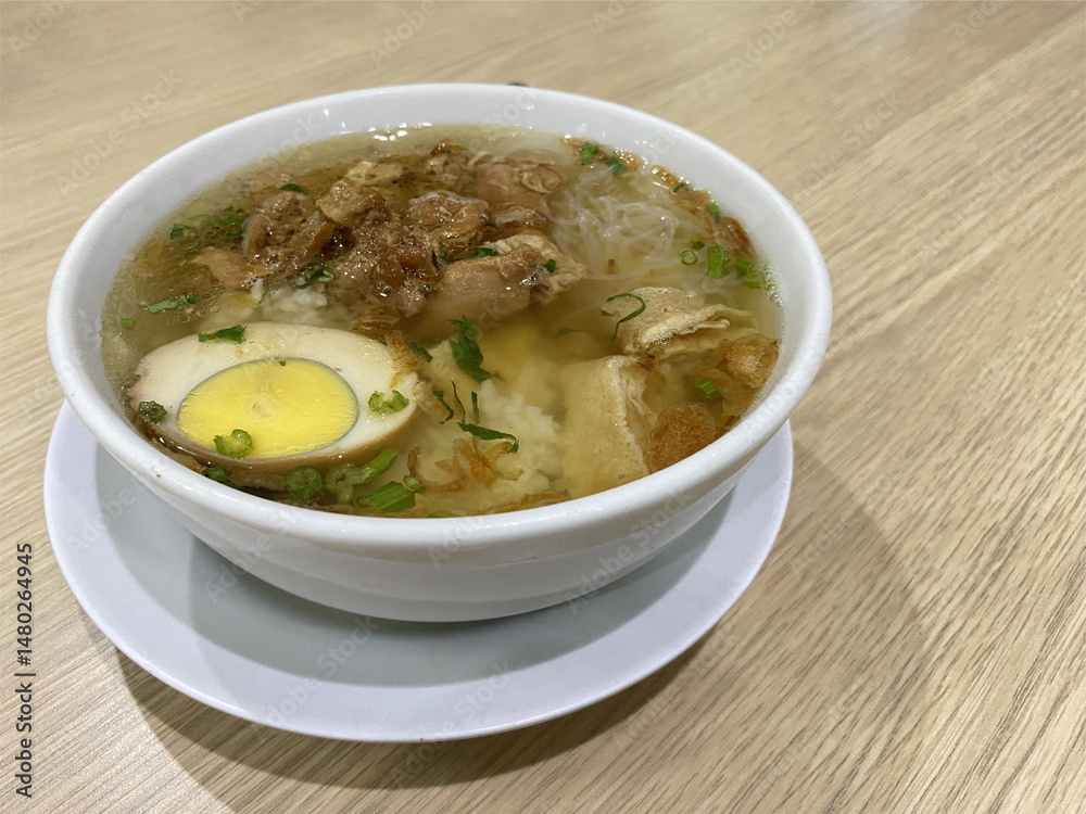 Timlo Soup is Authentic from Solo, Central Java, Indonesian. Made from Chicken, glass noodles, egg, Sosis Solo and Served with hot Clear Chicken Broth. Served on white Bowl.