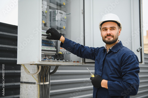 Foto Electrical engineer approving power distribution box installation on site