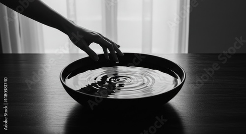 Hand Touching Water in a Bowl (Photo)