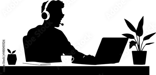 Silhouette of man working on laptop with headset at desk with plants  
