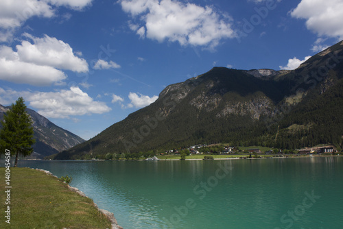 Lakeside view of Achensee in Tyrol, Austria with mountains and blue sky on a sunny day