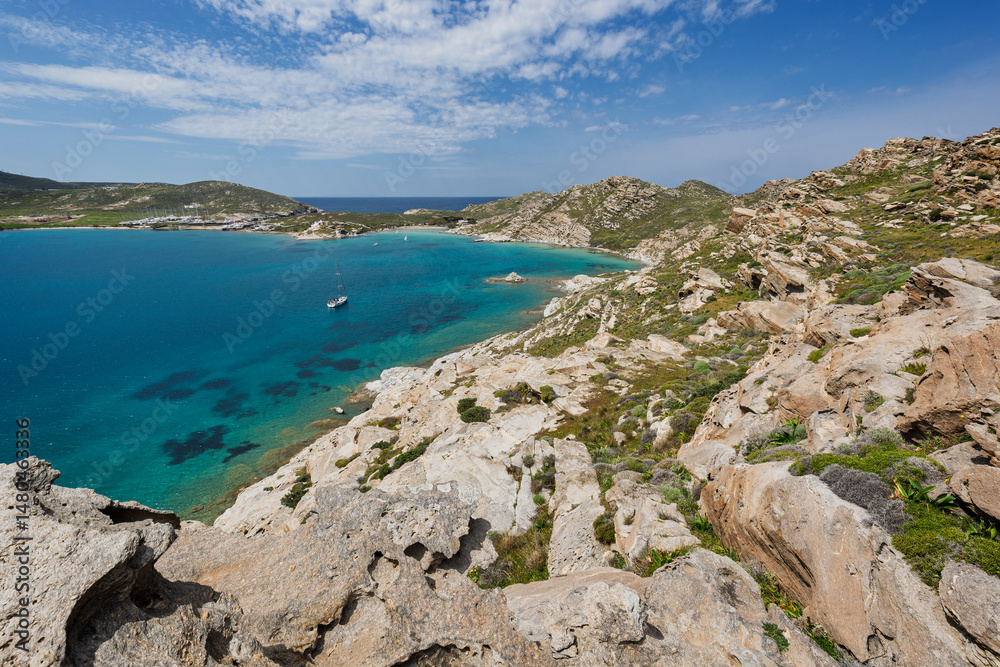 Fototapeta premium Rocky, lush and hilly landscape and the Aegean Sea at the Paros Park on Paros island in Greece viewed from above on a sunny day.