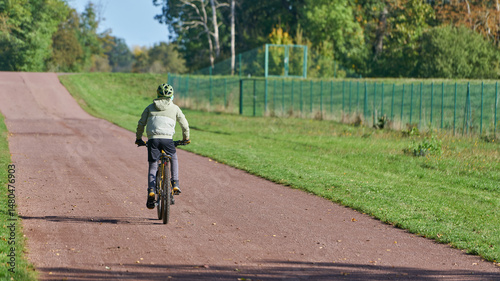 junger sportlicher Fahrradfahrer auf einem Weg im Herrenkrugpark in Magdeburg photo