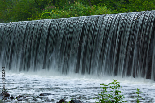 A blurred view of the Bloodgoods Pond Dam waterfall in Clark, New Jersey during summer