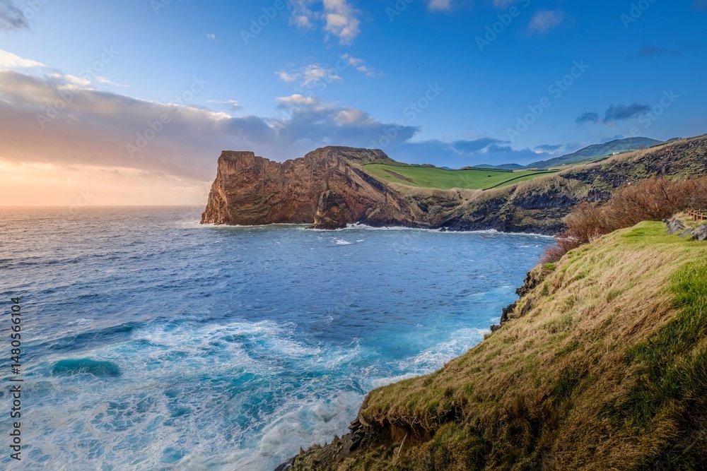 Fototapeta premium South coast of Sao Jorge (Azores islands) near Velas with volcanic rock Morro de Lemos. Breathtaking view of the dramatic cliffs and turquoise waters of Sao Jorge, Azores.