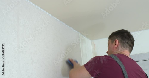 A man is making repairs in an apartment.