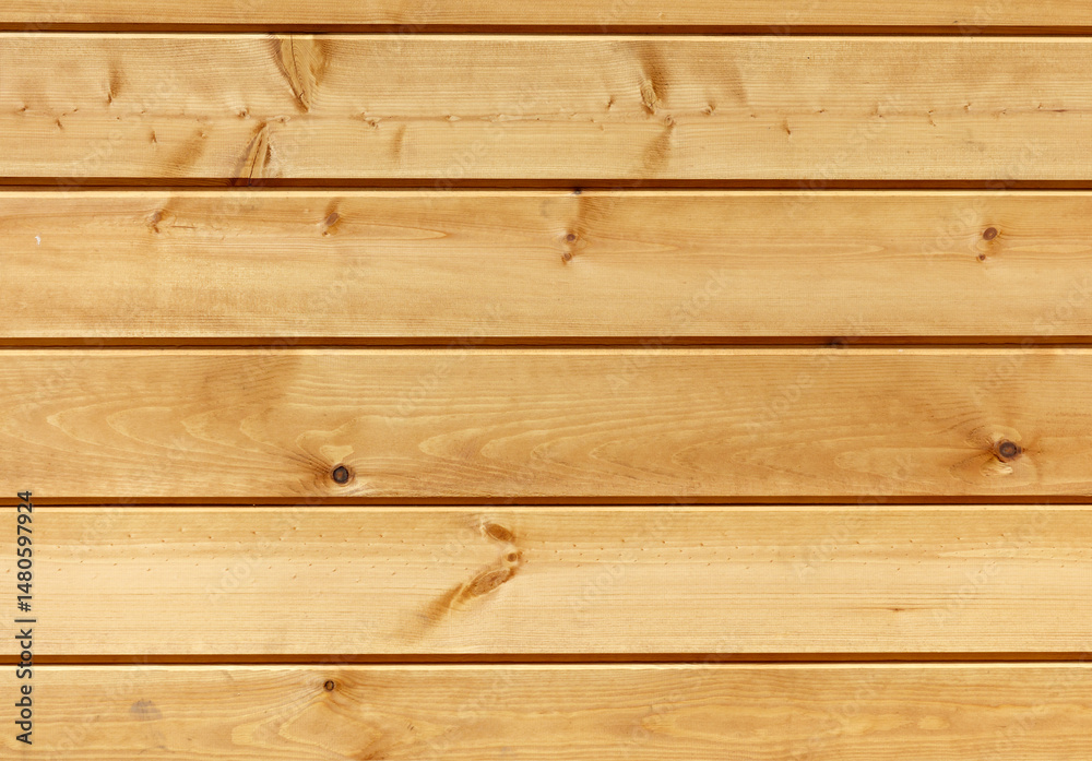 Fototapeta premium A wooden wall with a grainy texture and a light brown color