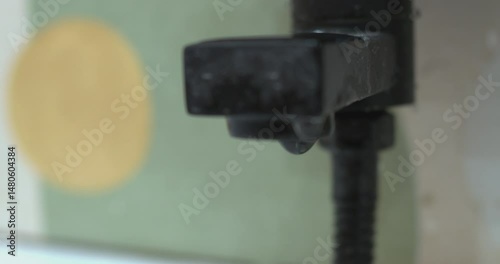 Water dripping from a faucet in slow motion