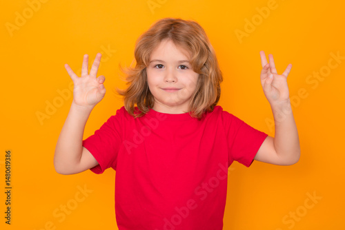 Kid sign ok, okay gesture on isolated studio background. Happy kid, happy and smiling emotions.