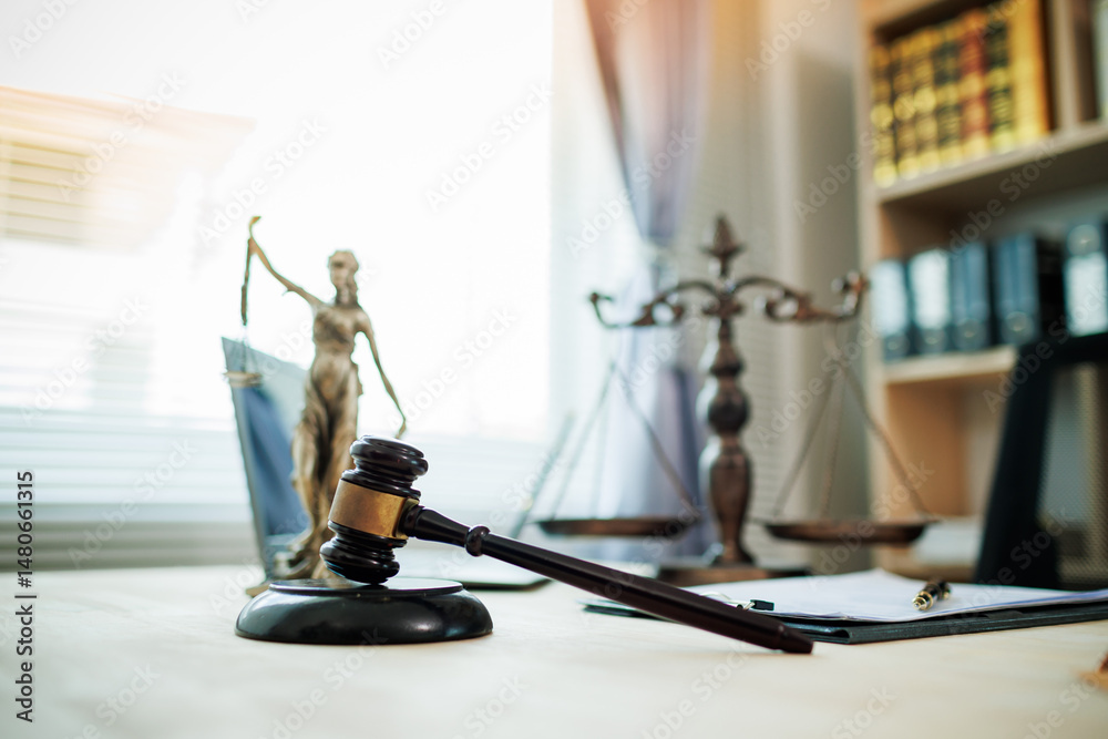 Lady Justice, scales, and a gavel placed on a judge’s desk represent fairness and integrity in law and courtroom proceedings.