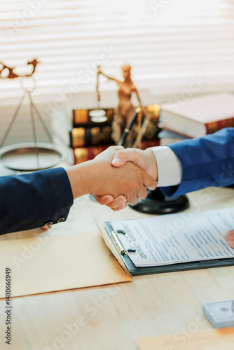 A client and lawyer shake hands to mark the completion of their legal agreement, symbolizing mutual understanding and commitment to legal representatio